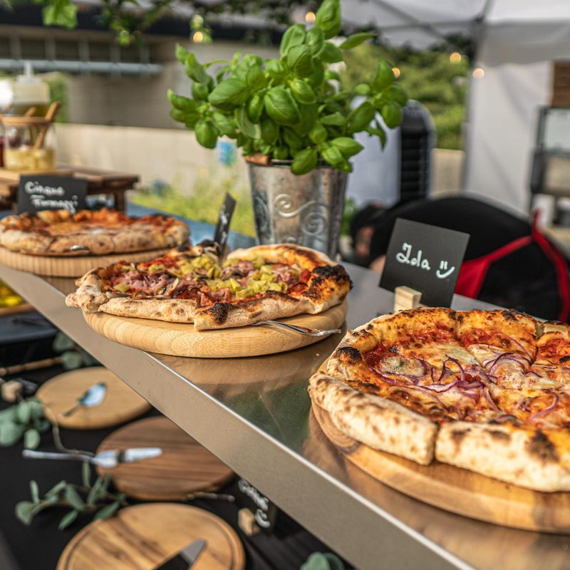 Pizza-Auswahl auf Holzbrettern mit Namensschildern